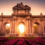 Sun shining through Alcala Gate in the city of Madrid Spain