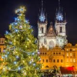 Big Christmas tree with blue lights in front of building in Prague